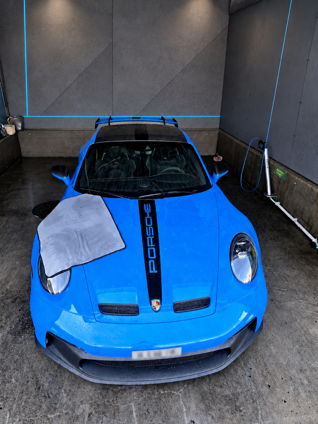Blauer Porsche während der professionellen Aussenreinigung